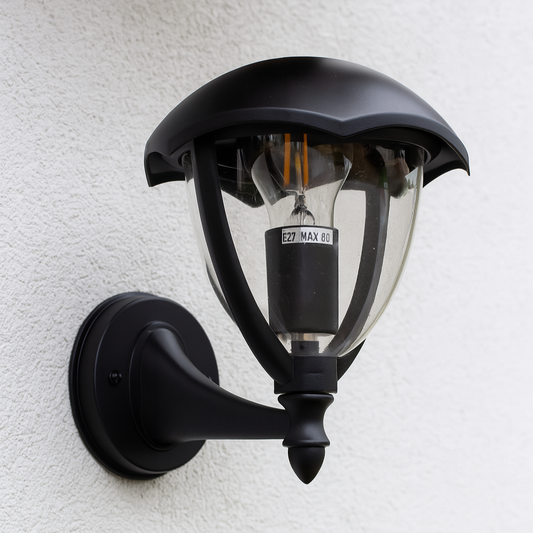 Klassische Außenwandleuchte in Schwarz mit eingebauter Glühbirne an der Hausfassade
