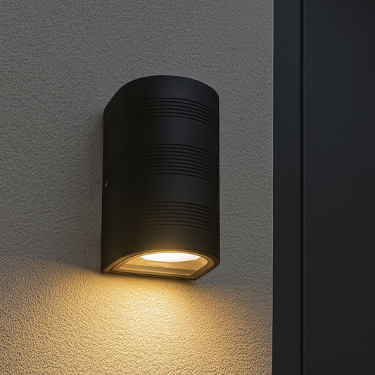 Schwarze Außenwandleuchte in Halbzylinderform mit gerichtetem Licht nach unten an Hausfassade montiert