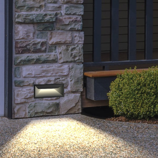 Moderne LED-Wandleuchte an einer Außenwand montiert, spendet neutrales Licht bei Dämmerung.