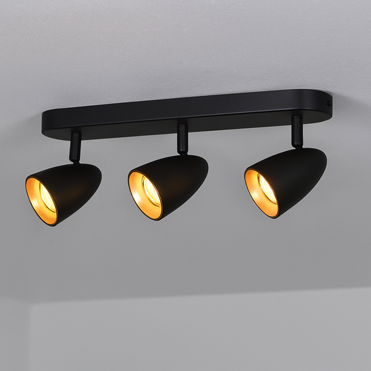 Stilvolle schwarze Deckenlampe mit warmgoldenem Innenreflektor, installiert an einer glatten weißen Decke.