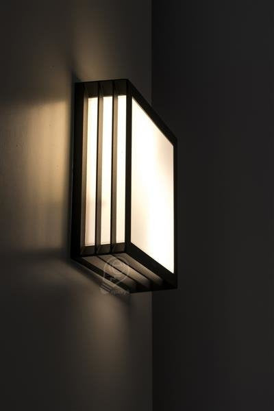 Moderne quadratische Wandaußenbeleuchtung mit Sockel E27 an einer Wand montiert in dunkler Umgebung