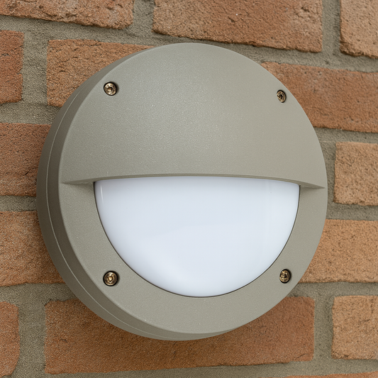 Runde LED Außenwandleuchte mit Halbblende in Grau montiert an einer Backsteinfassade