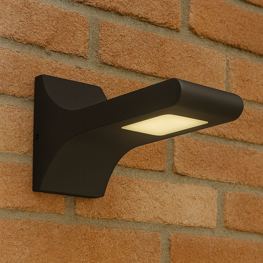 Geschwungene moderne LED Außenwandleuchte in Schwarz an einer Ziegelfassade montiert
