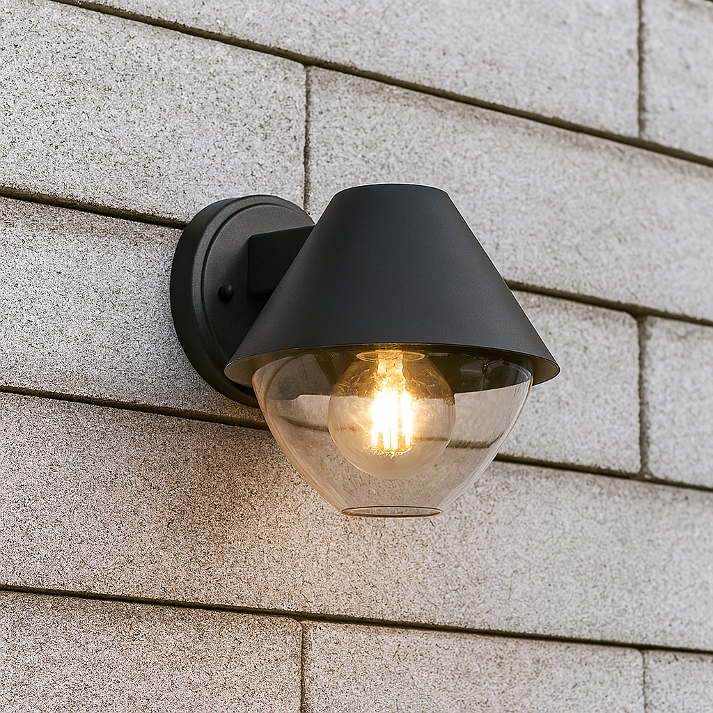 Schwarze Wandleuchte mit klarem Glasschirm und E27-Fassung, frontal fotografiert vor einer Hausfassade 